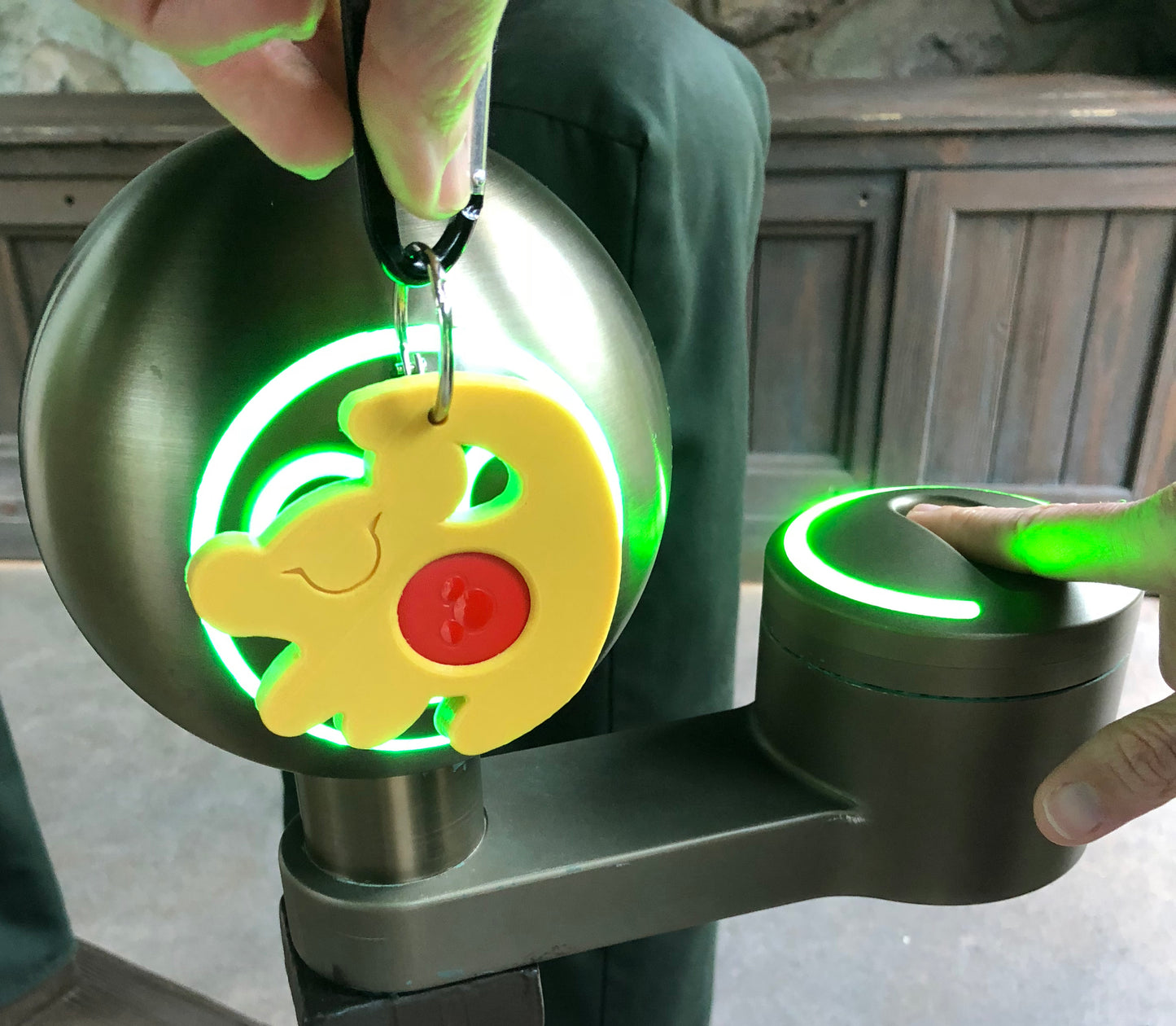 Simba Magic Band Buddy scanning into park kiosk with green ring lighting up
