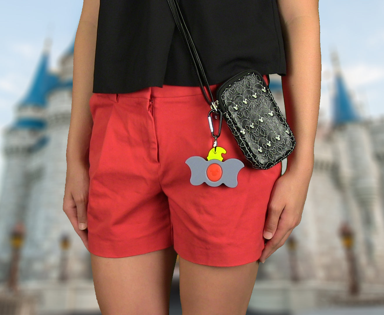 Girl using Dumbo Magic Band Buddy with a carabiner clipped to a pouch / purse