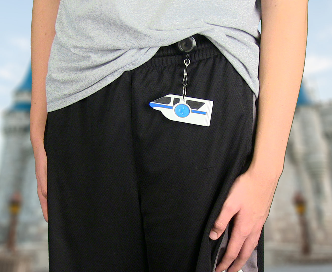 Boy using Monorail Magic Band Buddy with a retractable badge reel clipped to shorts